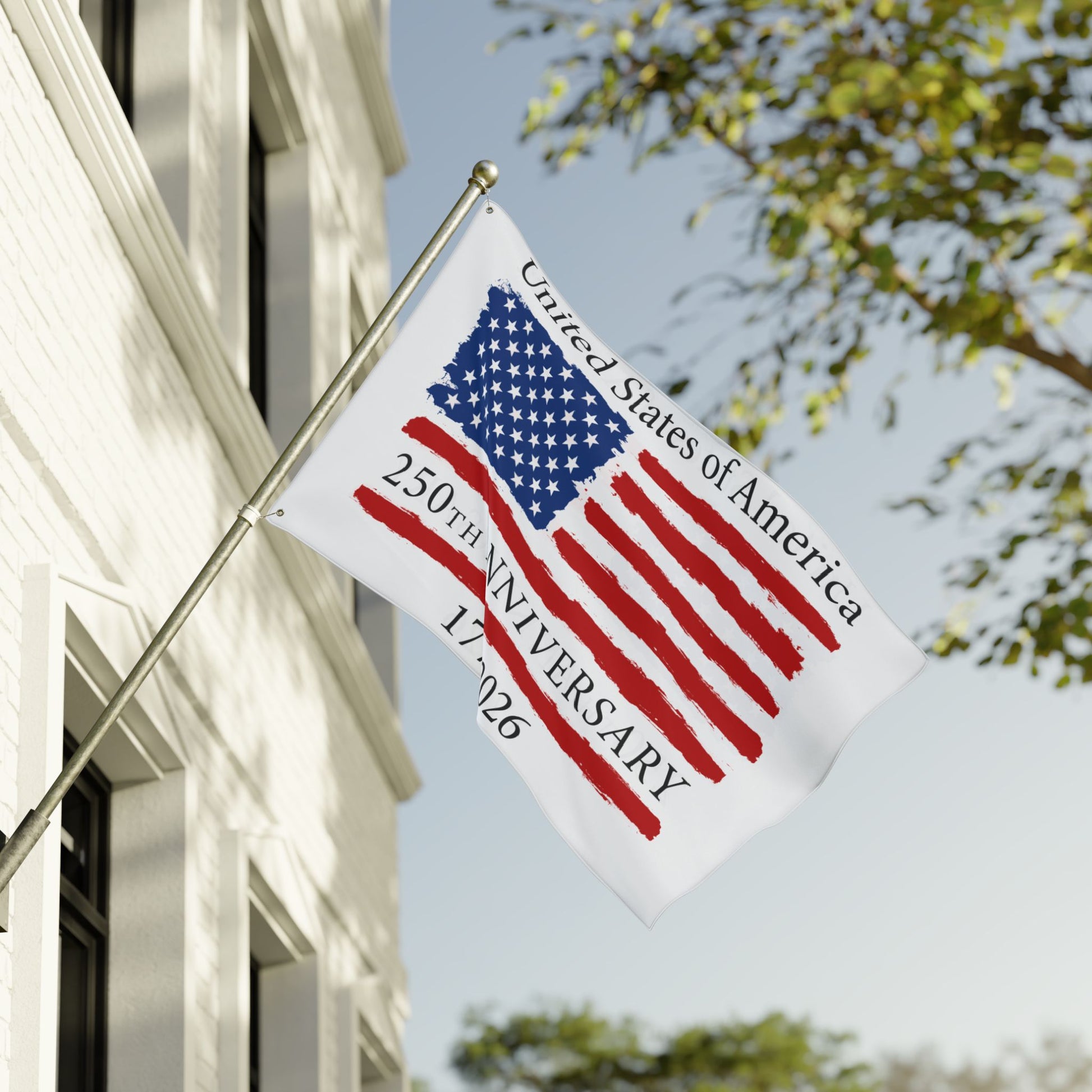 Flag commemorating the 250th anniversary of the United States of America on a building with trees in the background.