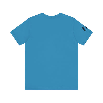 Blue t-shirt with a small flag patch on the sleeve against a white background