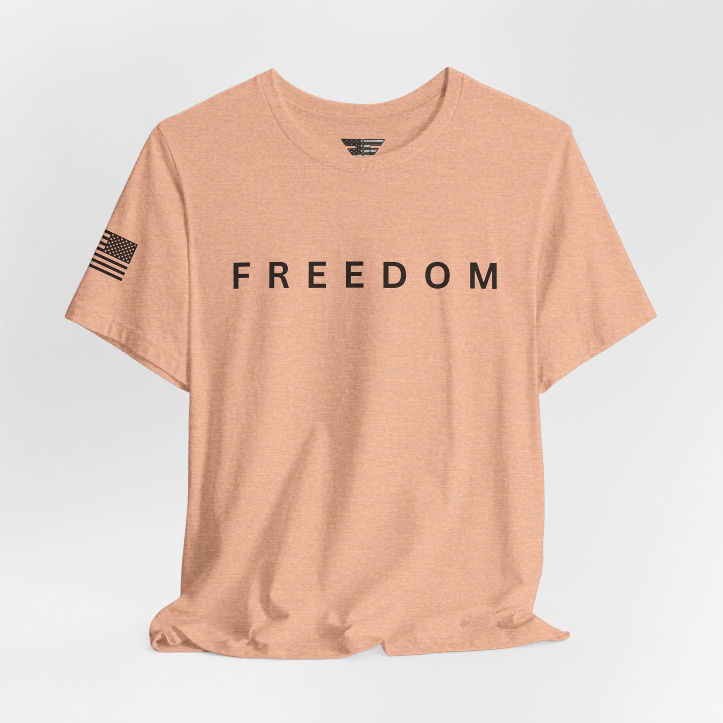 Beige t-shirt with 'FREEDOM' printed on it against a light gray background
