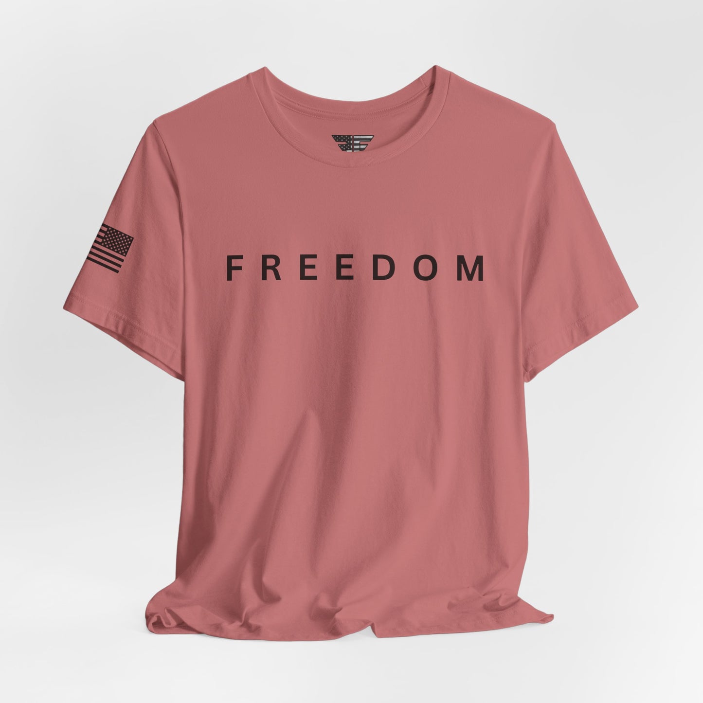 Pink t-shirt with 'FREEDOM' text on a light gray background