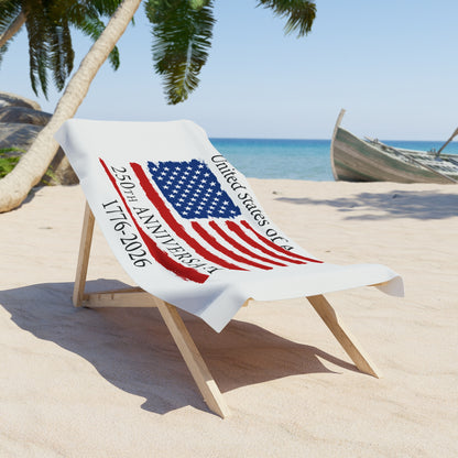 Beach towel with American flag design and text on a sand chair at a beach.
