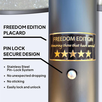 Close-up of a metallic cylindrical item with a black and gold 'FREEDOM EDITION' placard and a small button, shown with callout text describing a pin-lock secure design and stainless steel features.
