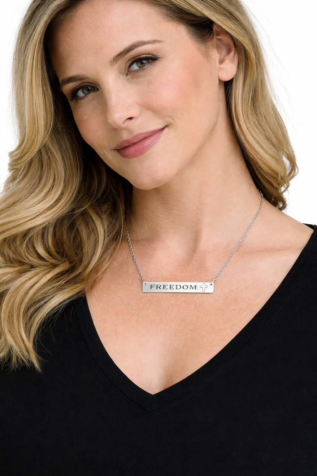 Woman wearing a necklace with a 'FREEDOM' pendant on a plain background