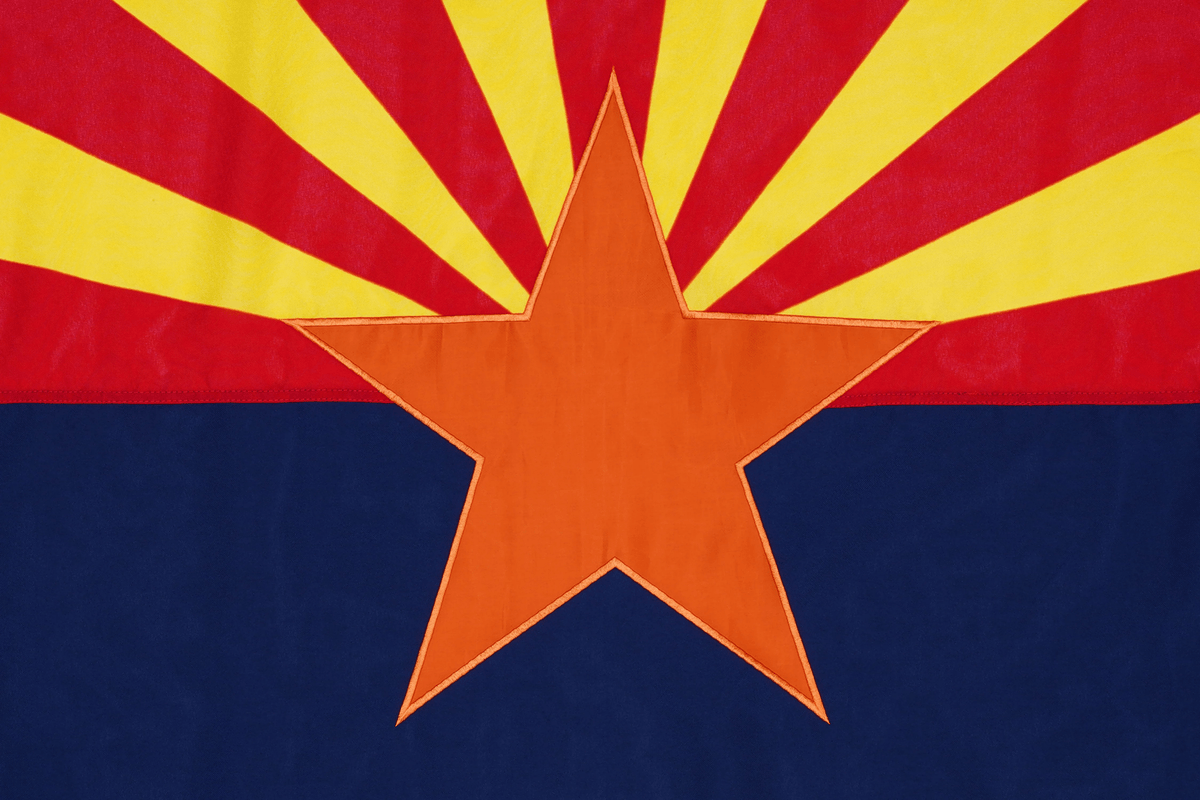 Flag with a large orange star and yellow and red rays on a blue background