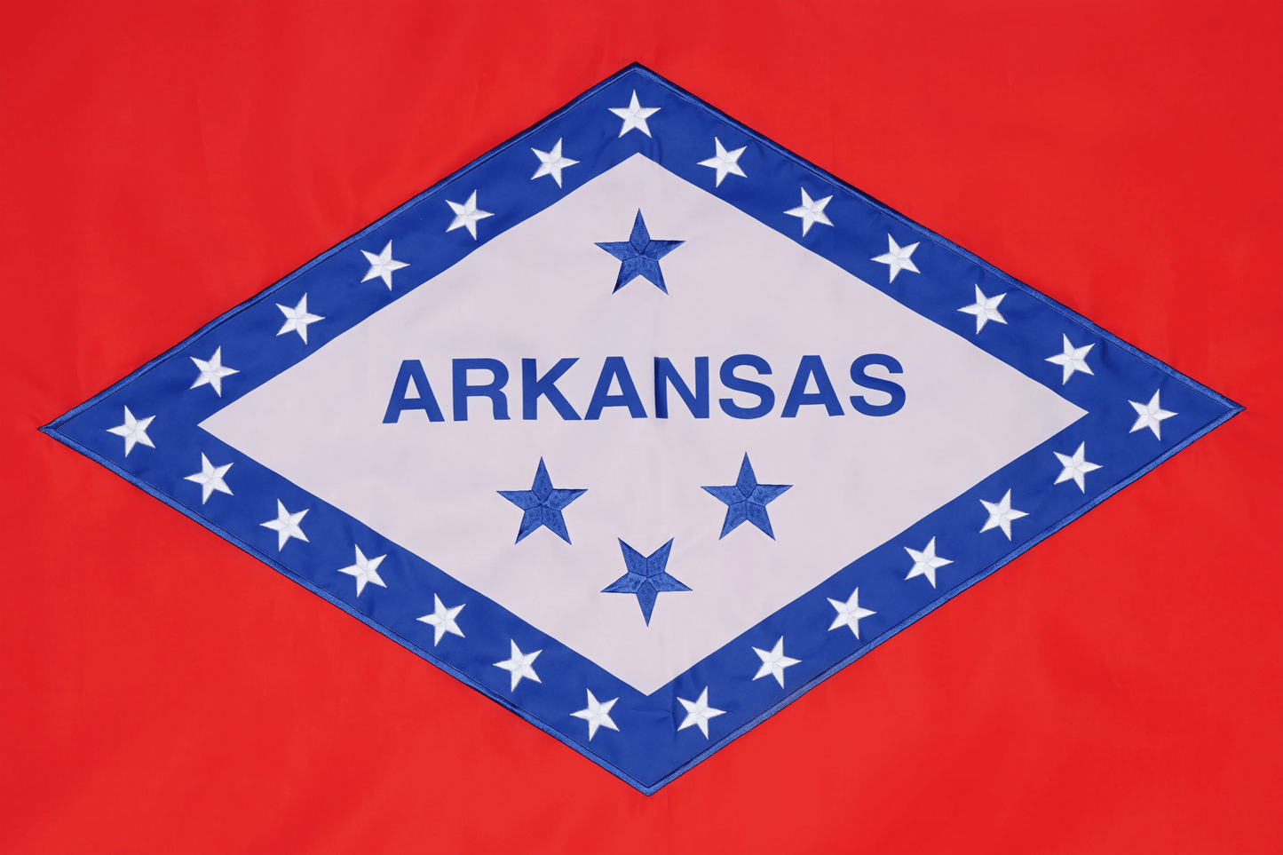 Flag of Arkansas with blue stars and 'ARKANSAS ' text on a red background