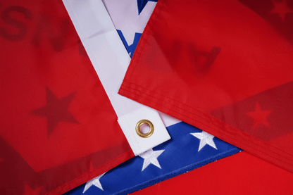 Close-up of American flags with stars and stripes, one featuring a gold eyelet.